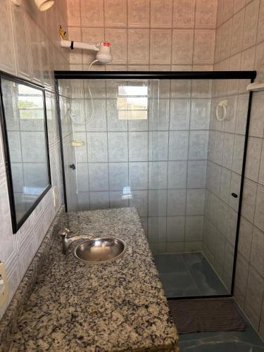 a bathroom with a sink and a shower at Condo Flat Solar de Aquários in Cabo Frio