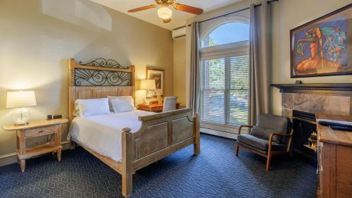 a bedroom with a bed and a chair and a window at The Bradley Boulder Inn in Boulder