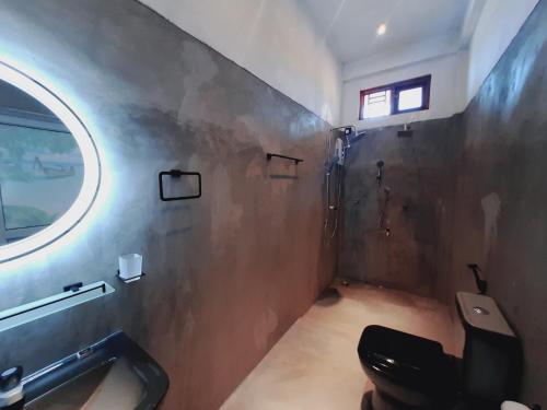 a bathroom with a toilet and a sink and a window at Drift Bay in Arugam Bay
