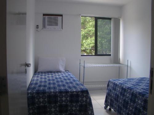 Habitación pequeña con 2 camas y ventana en Apartamento Ametista 6, en Maceió