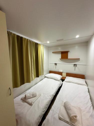 two beds in a small room with a window at Camping Bi Village - Maeva Vacansoleil in Valbandon
