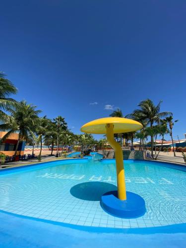 a large swimming pool with a yellow umbrella in the water at Fiesta Park Hotel in Jacobina