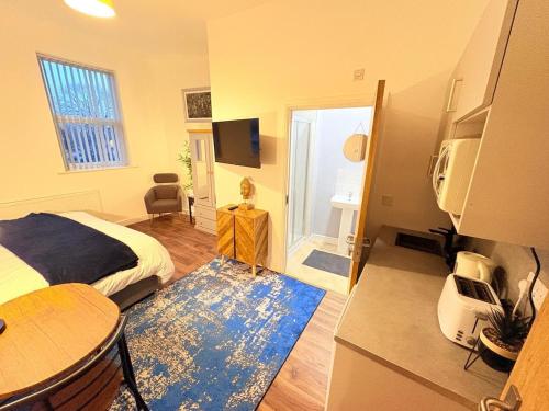a bedroom with a bed and a room with a television at Stylish Studio flat 4,ensuite,Kitchennete,Wifi,Parking,Smart TV,Contractors,NHS,Families welcome in West Bromwich