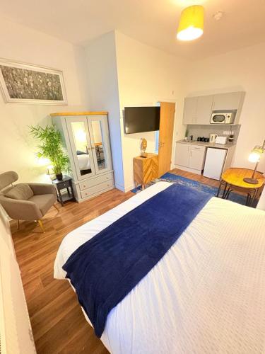 a bedroom with a large bed and a kitchen at Stylish Studio flat 4,ensuite,Kitchennete,Wifi,Parking,Smart TV,Contractors,NHS,Families welcome in West Bromwich