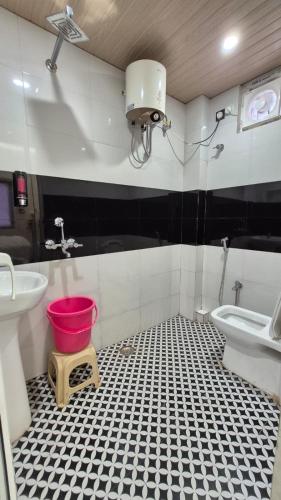 a bathroom with a sink and a toilet and a bucket at Hotel MRK VILLA in Varanasi