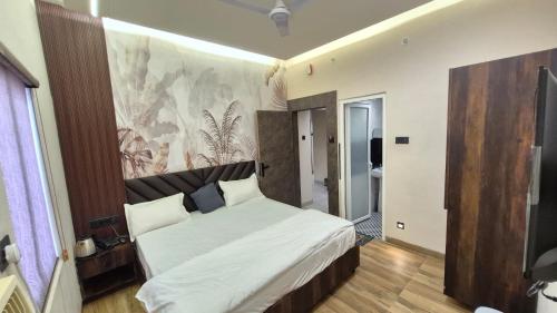 a bedroom with a large white bed in a room at Hotel MRK VILLA in Varanasi