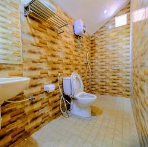 a bathroom with a toilet and a sink at Baron Ndut's Cottage in Mantaak