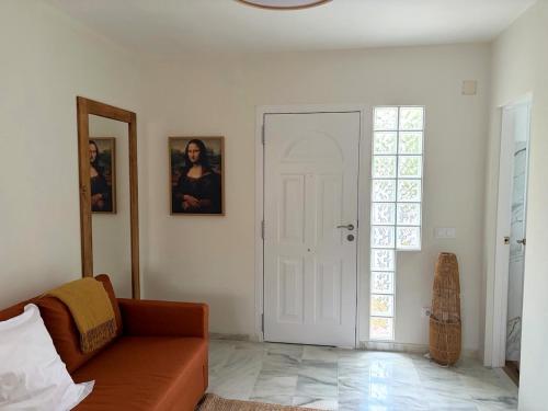 a living room with a couch and a white door at Studio-Guest House with Jacuzzi Spa and Sauna in Espartinas