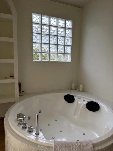 a white bath tub in a room with a window at Studio-Guest House with Jacuzzi Spa and Sauna in Espartinas