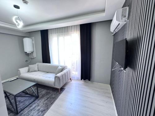 a living room with a couch and a tv at Ege Suit in Buca