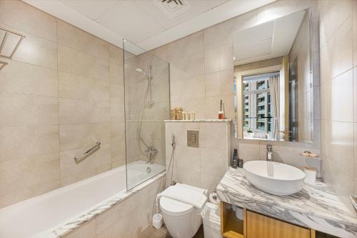 a bathroom with a toilet and a sink and a tub at Lux Apartments in BusinessBay, Canal views, Great Location in Dubai