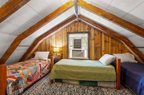 a bedroom with two beds in a attic at Knotty By Nature- Pet Friendly, Firepit, 150 Acres in Campton