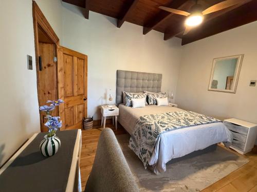 a bedroom with a large bed and a table at Windkraal Farm House in Bonnievale