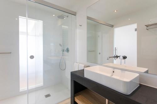 a white bathroom with a sink and a shower at Alfagar Prestige in Albufeira
