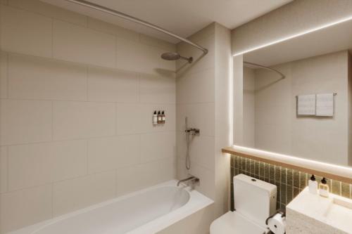 a bathroom with a tub and a toilet and a sink at DoubleTree by Hilton Wilkes-Barre in Wilkes-Barre