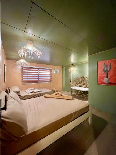 ein Schlafzimmer mit zwei Betten und einem Tisch darin in der Unterkunft L Casa in Coron