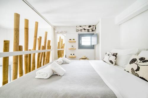 a white bedroom with towels on a bed at Mykonos Yialos Town Home Loft - by Hospirit in Mikonos