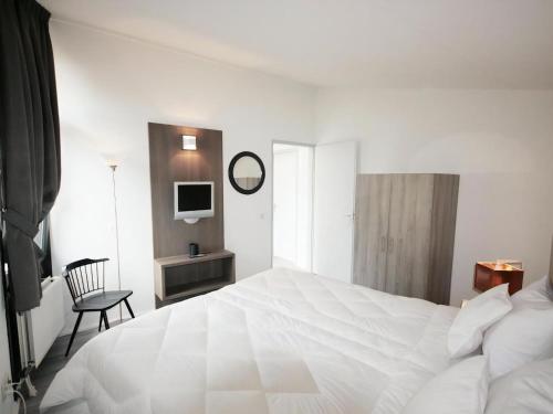 a white bedroom with a large white bed and a chair at Aquaronde 125 in Lemmer
