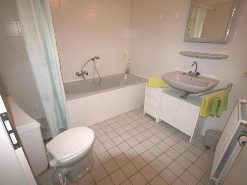 a bathroom with a toilet and a tub and a sink at Aquaronde 129 in Lemmer