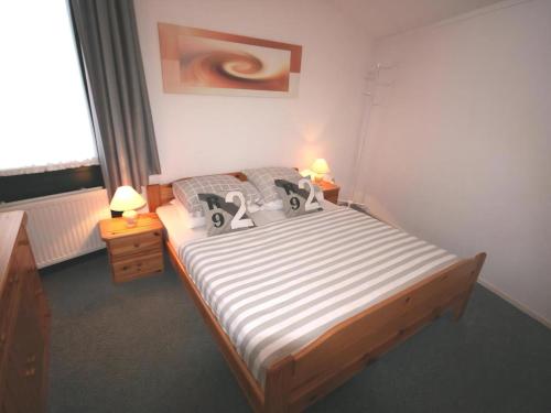 a bedroom with a large bed with two lamps on it at Aquaronde 129 in Lemmer