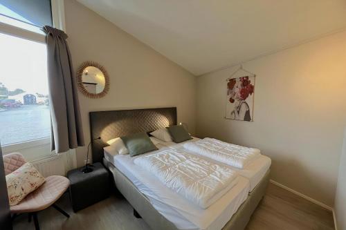 a bedroom with a large bed and a window at Aquaronde 122 in Lemmer