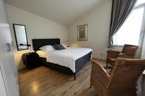 a bedroom with a bed and a chair at Aquaronde 120 in Lemmer