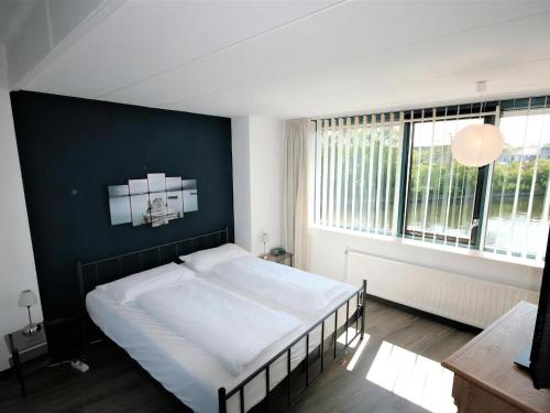 a bedroom with a large bed with a blue wall at Park Brekkense Wiel 058 in Lemmer