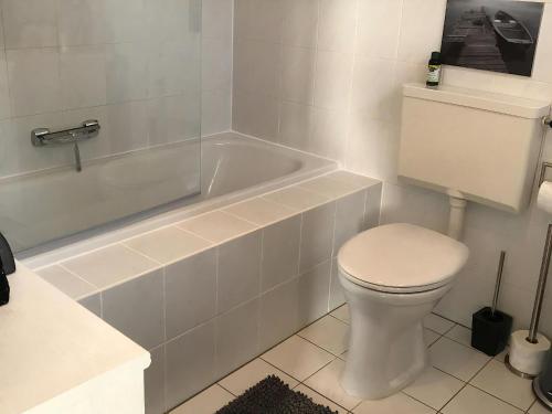 a bathroom with a toilet and a bath tub at Park Brekkense Wiel 058 in Lemmer