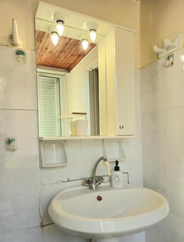 a bathroom with a sink and a mirror at Mary's apartment Elaia 3 in Elia Laconias
