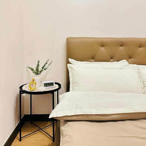 a bed with a side table with a clock on it at Celeste Stays- Celandine in Sampong