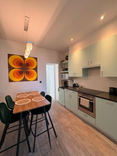 a kitchen with a table and chairs in a room at Royal South - Apartment Antwerp with Parkview in Antwerp
