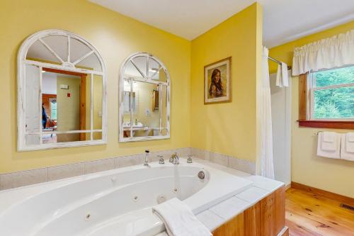 a bath tub in a bathroom with yellow walls at Chez Normand in Jefferson