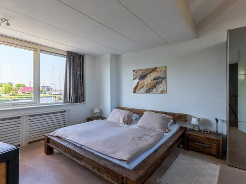a bedroom with a bed and a large window at Park Brekkense Wiel 069 in Lemmer