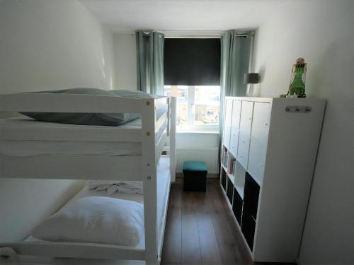 a bedroom with two bunk beds and a window at Park De Markol Leeuwerik 12 in Lemmer