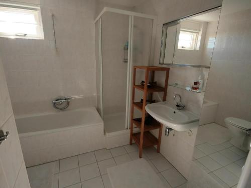 a bathroom with a tub shower and a sink at Park De Markol Leeuwerik 12 in Lemmer