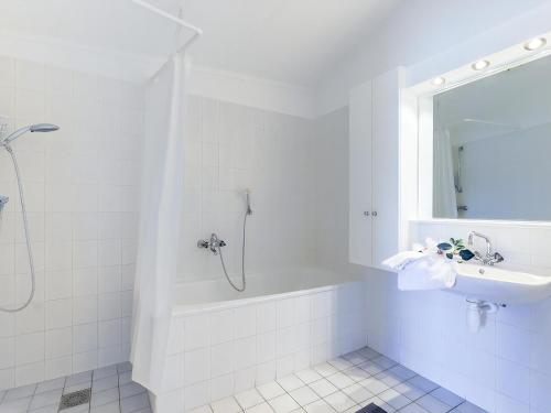 a white bathroom with a tub and a sink at Aquaronde 050 in Lemmer