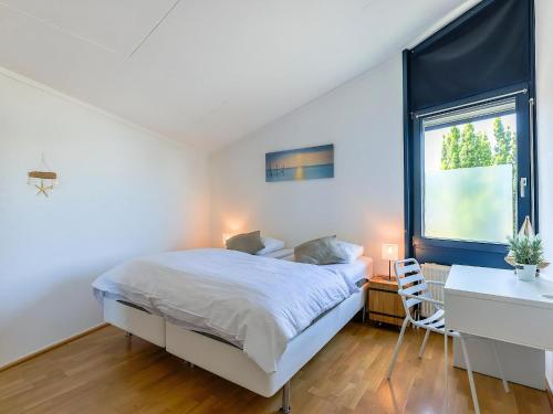 a bedroom with a bed and a desk and a window at Aquaronde 050 in Lemmer