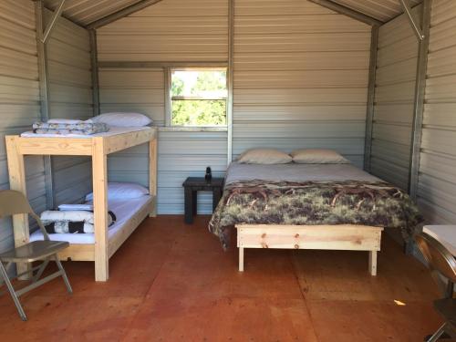 a bedroom with two bunk beds and a table at Bluebell Cabin, Glamour Cabin Camping, Stunning Night Sky in Monticello