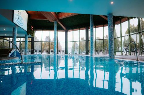 a large swimming pool with blue water in a building at SPA Hotel Olymp in Velingrad
