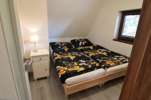 a small bed in a small room with a window at Andrea Chata in Štrba