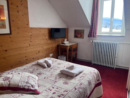 a bedroom with a bed with towels on it at Hôtel du Centre in Villard-de-Lans
