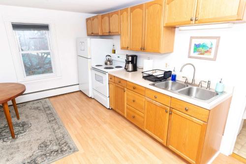 a kitchen with wooden cabinets and a sink at Centrally Located Winooski Apartment in Winooski