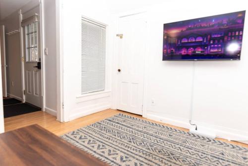 a living room with a television on a wall at Centrally Located Winooski Apartment in Winooski