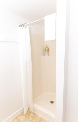 a bathroom with a shower with a white tub at Centrally Located Winooski Apartment in Winooski