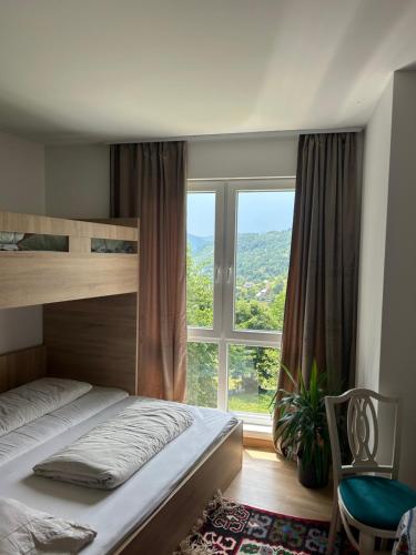 a bedroom with a bed and a large window at Konak Umoljani in Umoljani