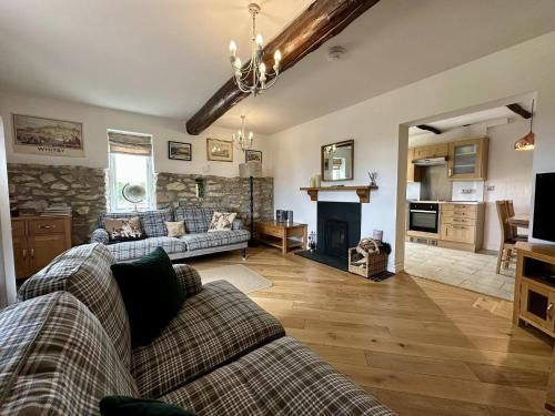 a living room with a couch and a fireplace at Kirkdale Cottage in Helmsley