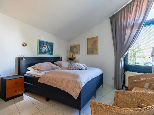 a bedroom with a bed and a window at Aquaronde 110 in Lemmer