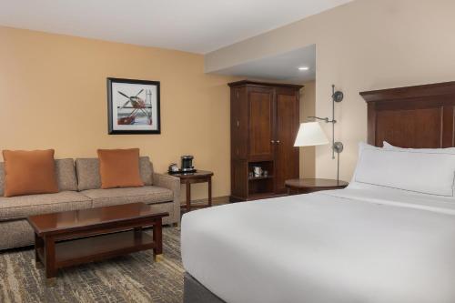 a hotel room with a bed and a couch at DoubleTree by Hilton Cincinnati Airport in Hebron