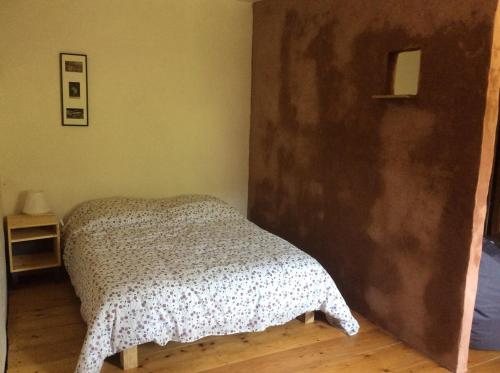 a bedroom with a bed and a wooden floor at Le RepAire de La SalAmandre in Ivrey