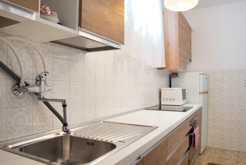 a small kitchen with a sink and a microwave at Tana del Manzoni in Barzio